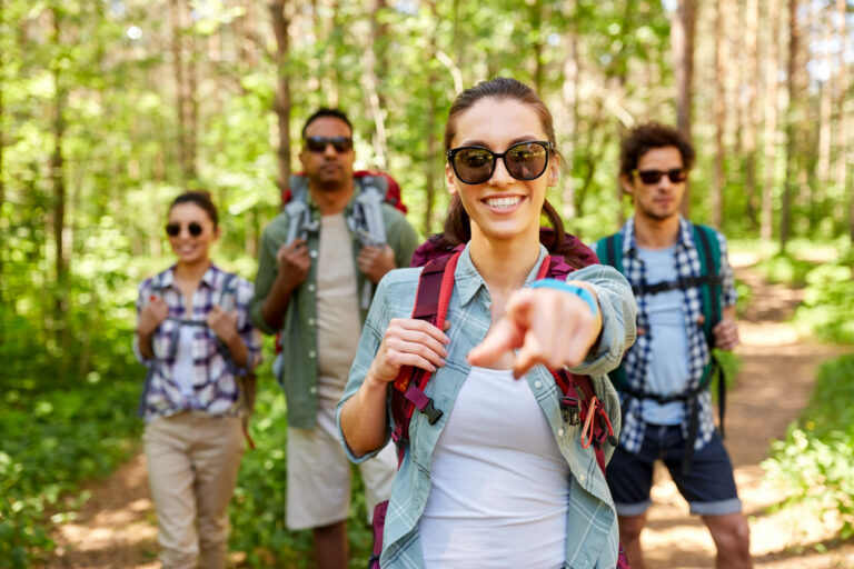 friends with backpacks on hike in forest